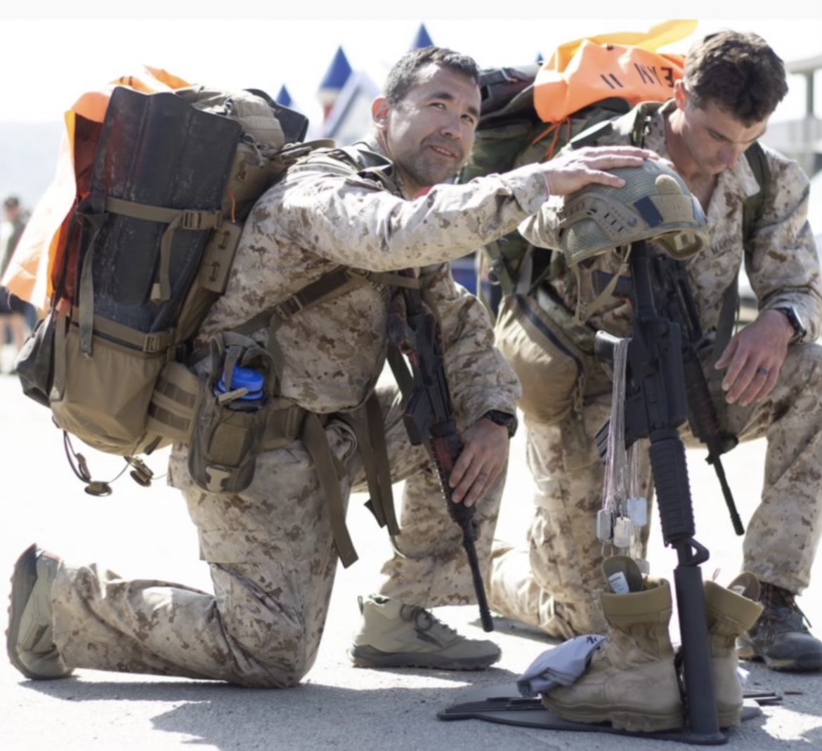 Service members helping one another carry the load